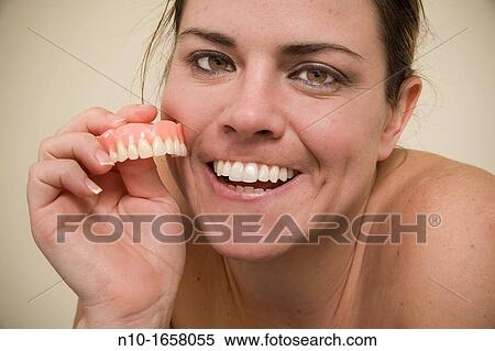 Woman holding false teeth View Large Photo Image Stock Photography - Woman holding false teeth. Fotosearch