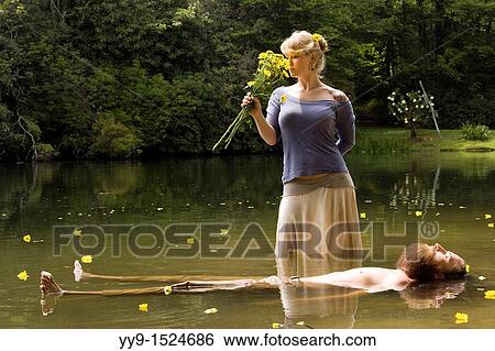 Woman holding flowers standing over floating man - Cedar Mountain, North Carolina, USA View Large Photo Image Stock Photograph - Woman holding flowers standing over floating man - Cedar Mountain, North Carolina, USA. Fotosearch