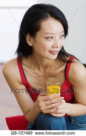 Stock Photo - Woman holding glass orange juice. Fotosearch