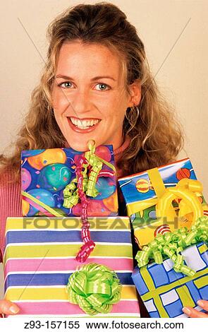Woman holding lots of wrapped gifts View Large Photo Image Stock Photography - Woman holding lots of wrapped gifts. Fotosearch