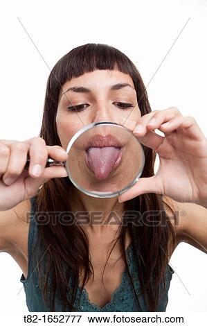 Woman holding magnifying glass and sticking her tongue out View Large Photo Image Stock Photo - Woman holding magnifying glass and sticking her tongue out. Fotosearch