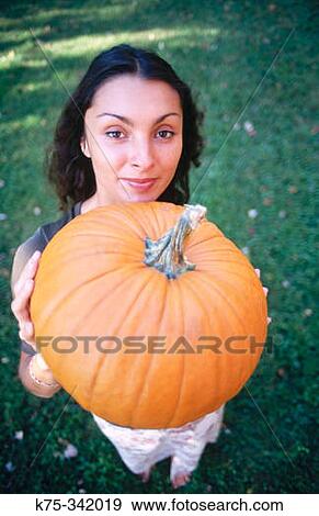 Woman holding pumpkin View Large Photo Image Stock Photo - Woman holding pumpkin. Fotosearch