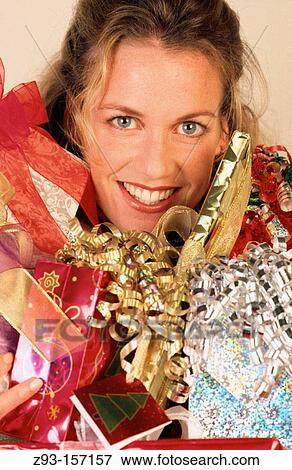 Woman holding wrapped Christmas gifts View Large Photo Image Stock Photo - Woman holding wrapped Christmas gifts. Fotosearch