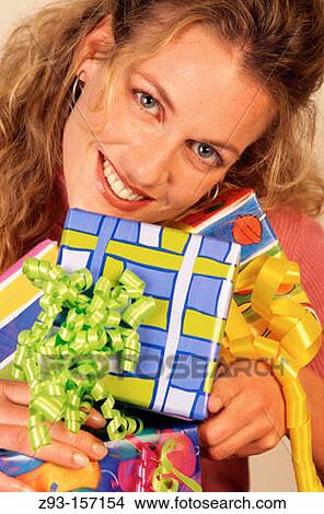 Woman holding wrapped gifts View Large Photo Image Picture - Woman holding wrapped gifts. Fotosearch