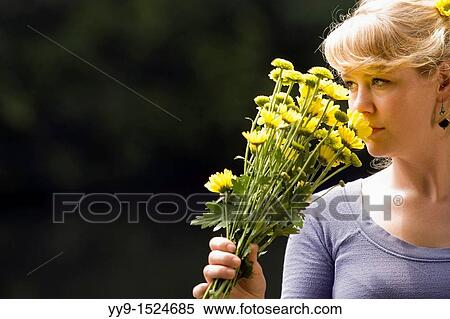 Stock Photography - Woman holding yellow flowers - Cedar Mountain, North Carolina, USA. Fotosearch