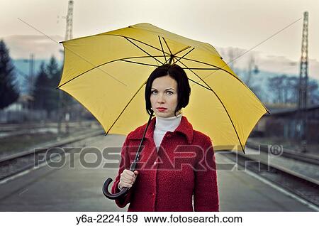 Stock Photo - Woman holding yellow umbrella.. Fotosearch