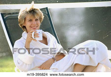 Picture - woman in a bathrobe drinking coffee/tea. Fotosearch