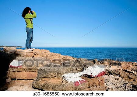 Stock Image - Woman in a GR footpath Landscape of Perello beach, and Mediterranean sea Tarragona province Spain. Fotosearch