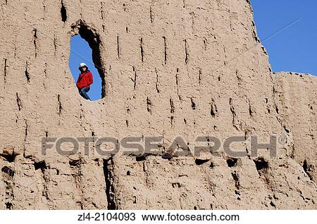 Woman in a hole in a wall of Qyzyl Qala desert fortress. Uzbekistan, Karakalpakstan. Model Released. View Large Photo Image Stock Image - Woman in a hole in a wall of Qyzyl Qala desert fortress. Uzbekistan, Karakalpakstan. Model Released.. Fotosearch
