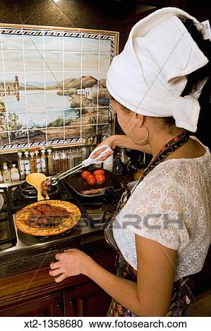 Woman in a kitchen cooking breakfast wearing an apron and hair towel View Large Photo Image Stock Image - Woman in a kitchen cooking breakfast wearing an apron and hair towel. Fotosearch