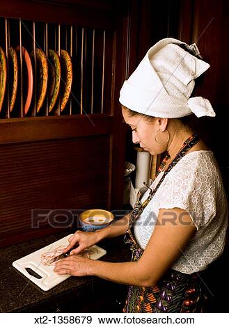 Woman in a kitchen cooking cutting meat on a board wearing an apron and hair towel View Large Photo Image Stock Photo - Woman in a kitchen cooking cutting meat on a board wearing an apron and hair towel. Fotosearch