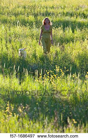 Woman in a meadow with her dog View Large Photo Image Stock Photo - Woman in a meadow with her dog. Fotosearch