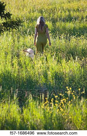 Woman in a meadow with her dog View Large Photo Image Stock Photograph - Woman in a meadow with her dog. Fotosearch