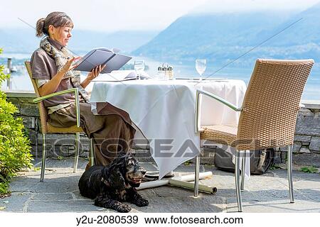 Woman in a restaurant and reading the menu in ascona ticino switzerland. View Large Photo Image Stock Photo - Woman in a restaurant and reading the menu in ascona ticino switzerland.. Fotosearch