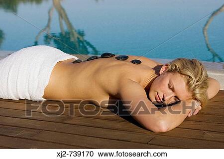 Stock Image - Woman in a Spa with stone therapy. Fotosearch