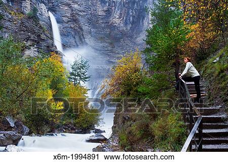 Stock Image - Woman in a viewpoint. Sorrosal waterfall. Broto, Huesca, Spain, Europe.. Fotosearch