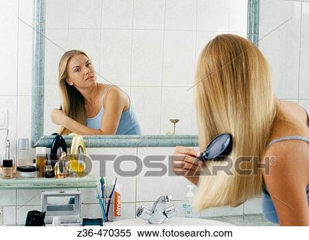 Stock Photography - Woman in bathroom doing hair. Fotosearch