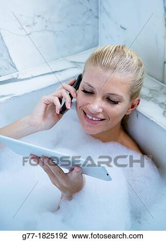 Woman in bathtub with tablet View Large Photo Image Stock Image - Woman in bathtub with tablet. Fotosearch