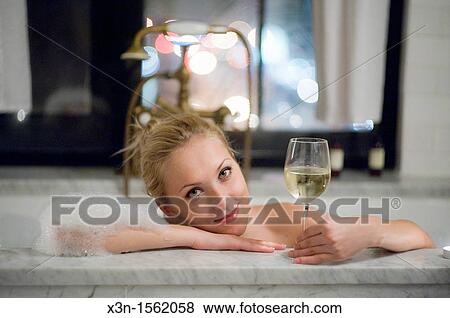 Stock Photo - Woman in bathtub with white wine, Bowery Hotel, New York City USA. Fotosearch