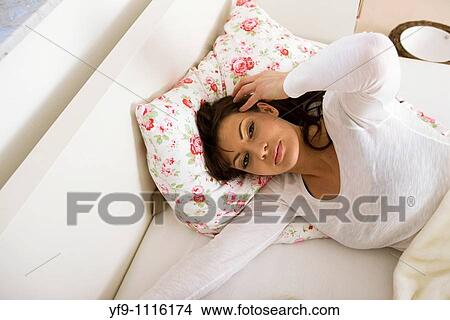 Woman in bed resting her head on her pillow. View Large Photo Image Picture - Woman in bed resting her head on her pillow.. Fotosearch