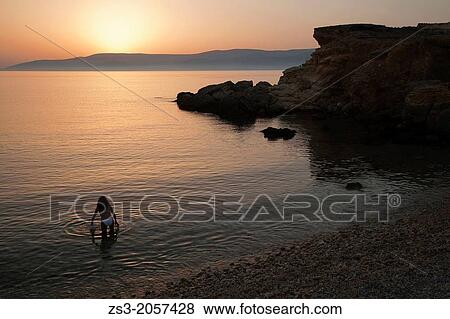 Stock Photo - Woman in bikini going to have a swim, Koufonissi, Cyclades Islands, Greek Islands, Greece, Europe.. Fotosearch