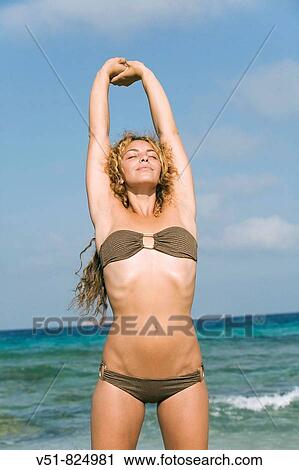 Woman in bikini stretching by the sea View Large Photo Image Stock Image - Woman in bikini stretching by the sea. Fotosearch