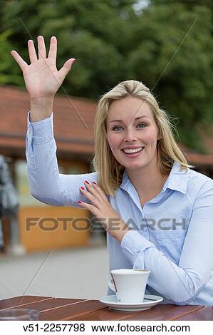 Woman in Cafe waving or asking for the bill View Large Photo Image Stock Photo - Woman in Cafe waving or asking for the bill. Fotosearch