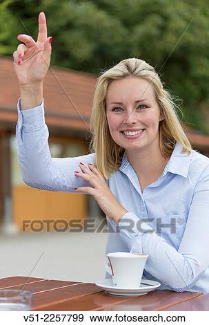 Woman in Cafe waving or asking for the bill View Large Photo Image Stock Photo - Woman in Cafe waving or asking for the bill. Fotosearch