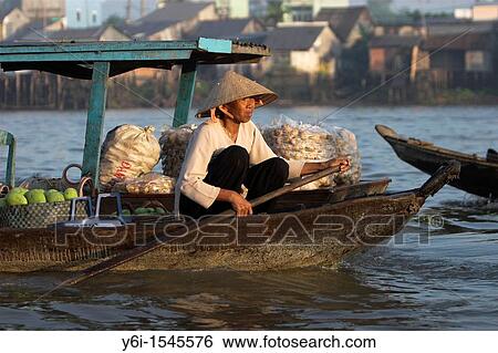 Woman in conical hat paddles her boat of produce at Cai Ran floating market near Can Tho Vietnam View Large Photo Image Stock Photograph - Woman in conical hat paddles her boat of produce at Cai Ran floating market near Can Tho Vietnam. Fotosearch