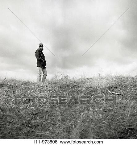 Woman in field on cloudy day. View Large Photo Image Stock Photograph - Woman in field on cloudy day.. Fotosearch