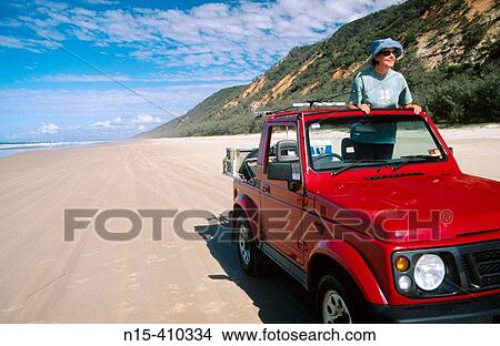 Woman in four wheel drive car on Rainbow Beach, near Fraser Island, Queensland, Australia View Large Photo Image Picture - Woman in four wheel drive car on Rainbow Beach, near Fraser Island, Queensland, Australia. Fotosearch