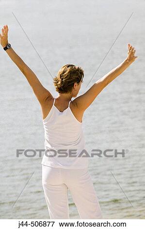 Woman in front of lake with arms open View Large Photo Image Stock Photo - Woman in front of lake with arms open. Fotosearch