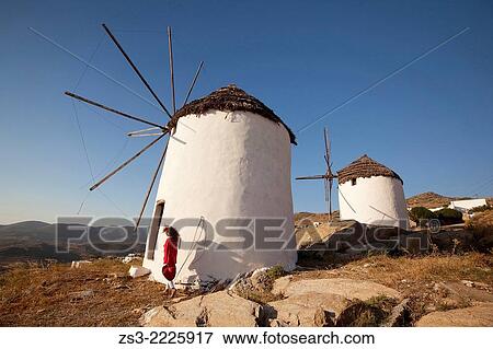 Stock Photo - Woman in front of old windmills in town center Chora, Ios, Cyclades Islands, Greek Islands, Greece, Europe.. Fotosearch