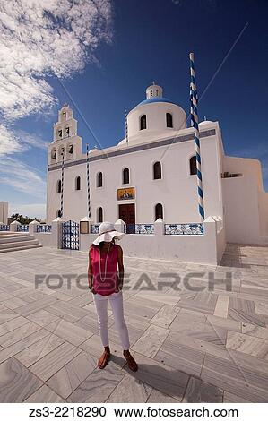 Stock Image - Woman in front of the main church in Oia town, Santorini, Cyclades Islands, Greek Islands, Greece, Europe.. Fotosearch