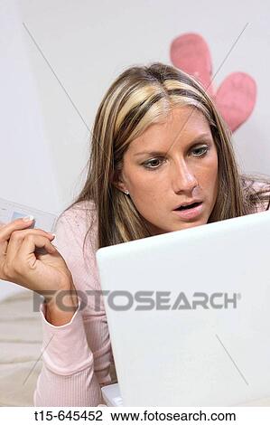 Woman in her 20's all dressed up with high heels shopping online in bed trying to decide to buy or not to buy View Large Photo Image Stock Image - Woman in her 20's all dressed up with high heels shopping online in bed trying to decide to buy or not to buy. Fotosearch