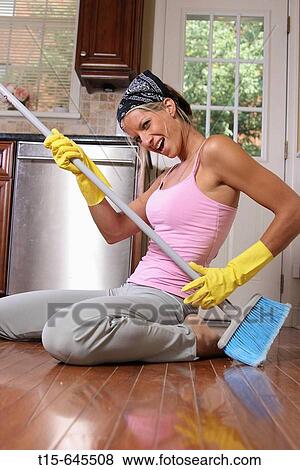 woman in her 20's doing chore having fun playing guitar using the broom in the kitchen View Large Photo Image Stock Photo - woman in her 20's doing chore having fun playing guitar using the broom in the kitchen. Fotosearch