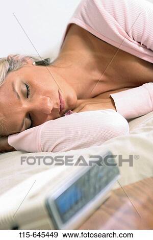 Woman in her 20's sleeping restfully with alarm close by View Large Photo Image Stock Photo - Woman in her 20's sleeping restfully with alarm close by. Fotosearch