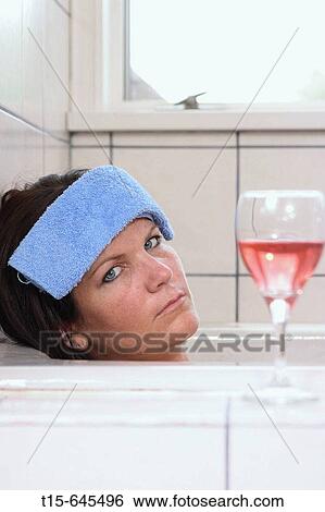 woman in her 30's taking a bath having a glass of red wine looking exhausted, tired, depressed View Large Photo Image Stock Photograph - woman in her 30's taking a bath having a glass of red wine looking exhausted, tired, depressed. Fotosearch