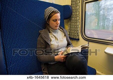Stock Photo - Woman in her early 30s reading on train Czech Republic Europe. Fotosearch