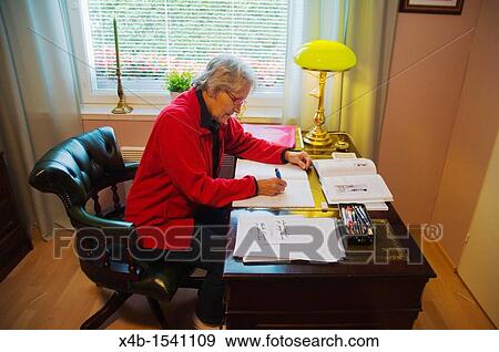 Woman in her early 70s doing paperwork Finland Europe View Large Photo Image Stock Photo - Woman in her early 70s doing paperwork Finland Europe. Fotosearch