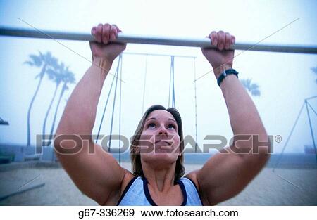 Woman in her mid 20's doing pull ups. Venice. California. USA. View Large Photo Image Stock Photo - Woman in her mid 20's doing pull ups. Venice. California. USA.. Fotosearch