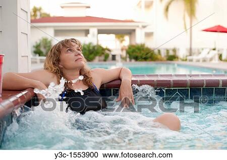 Woman in hot tub at a swimming pool area of a hotel View Large Photo Image Stock Image - Woman in hot tub at a swimming pool area of a hotel. Fotosearch