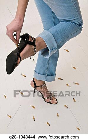 woman in jeans and high heel shoes, crushing a cigarette on their sole, close up, to stop smoking View Large Photo Image Picture - woman in jeans and high heel shoes, crushing a cigarette on their sole, close up, to stop smoking. Fotosearch