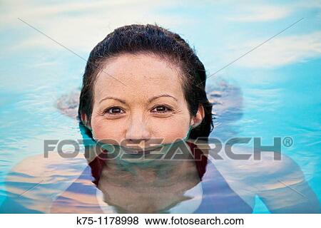 Stock Photo - Woman in pool with her mouth in the water. Fotosearch