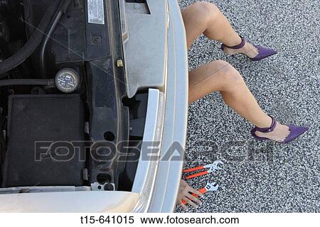 Woman in purple high heels getting under a car fixing it only show her legs, hands and tools. View Large Photo Image Stock Photography - Woman in purple high heels getting under a car fixing it only show her legs, hands and tools.. Fotosearch