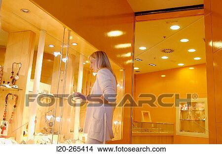 Woman in shopping center, looking at jewelry View Large Photo Image Picture - Woman in shopping center, looking at jewelry. Fotosearch
