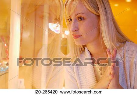 Stock Image - Woman in shopping center, looking at jewelry. Fotosearch