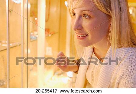 Woman in shopping center, looking at jewelry View Large Photo Image Stock Photo - Woman in shopping center, looking at jewelry. Fotosearch