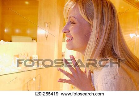 Woman in shopping center, looking at jewelry View Large Photo Image Stock Photo - Woman in shopping center, looking at jewelry. Fotosearch