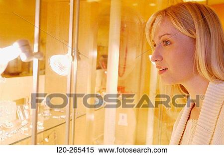 Woman in shopping center, looking at jewelry View Large Photo Image Stock Photography - Woman in shopping center, looking at jewelry. Fotosearch
